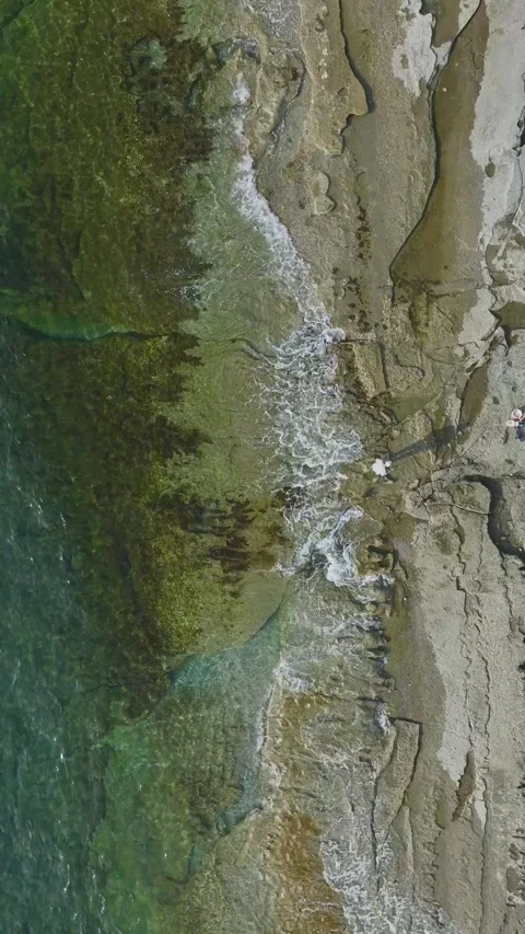 Vertical drone perspective of coastal line with crystal clear water Stock Footage 341900495