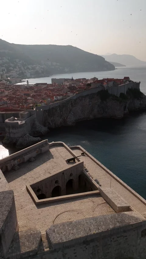 Vertical Drone Pull Back From Dubrovnik Fort Lovrijenac to Reveal Sea Cliffs 4K Vídeos de archivo 337848901