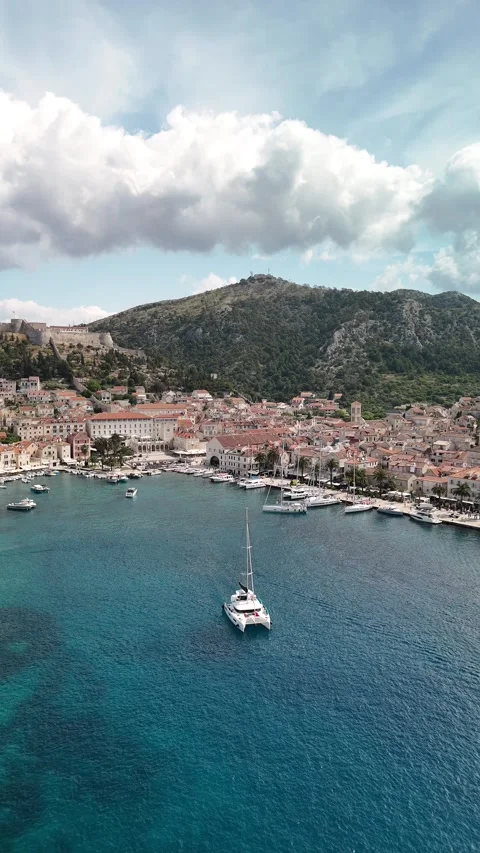 Vertical Drone Pull Back: Hvar Town &amp; Fortress Reveal, Hvar Island, Croatia Video stock 313483776