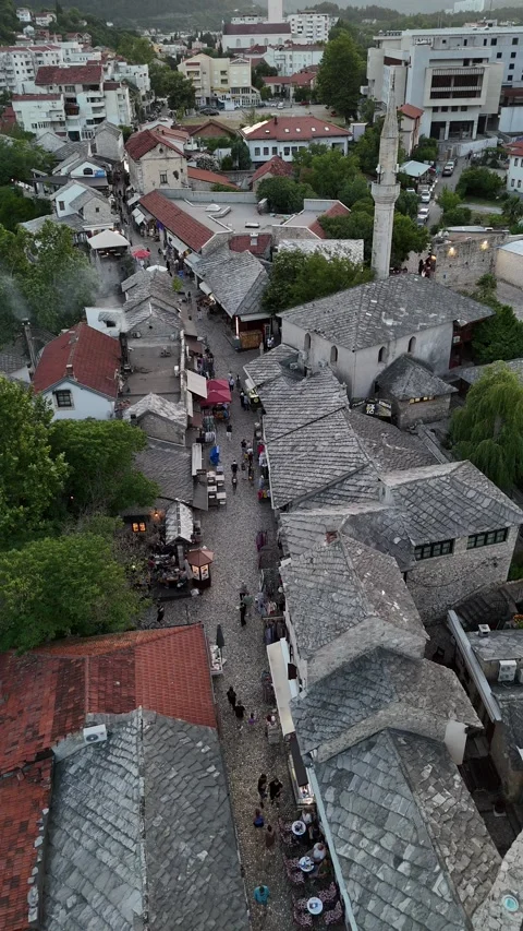 Vertical Drone Pull Back Over Mostar Old Town Bazaar Street and Shoppers 4K Stock Footage 337830880