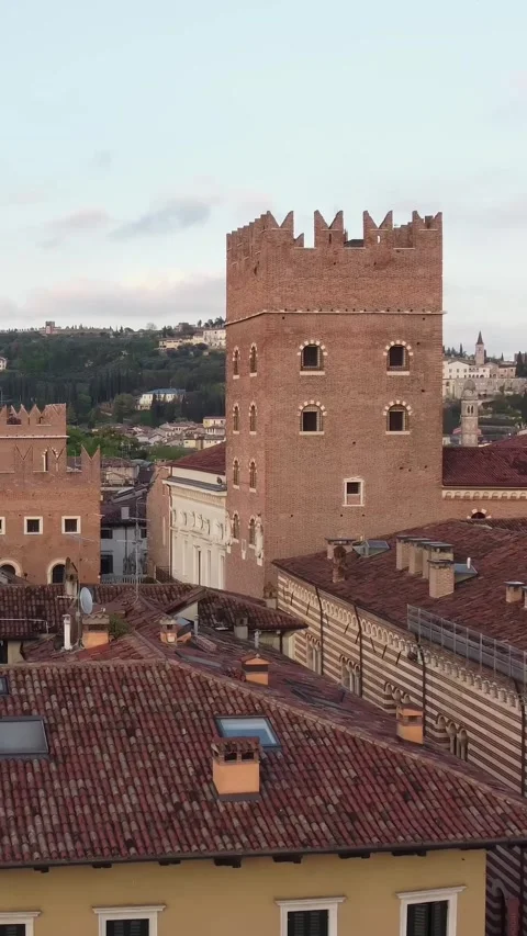 Vertical drone pull out from Torre dei Lamberti over tiled rooftops in Verona Vídeos de archivo 313097157
