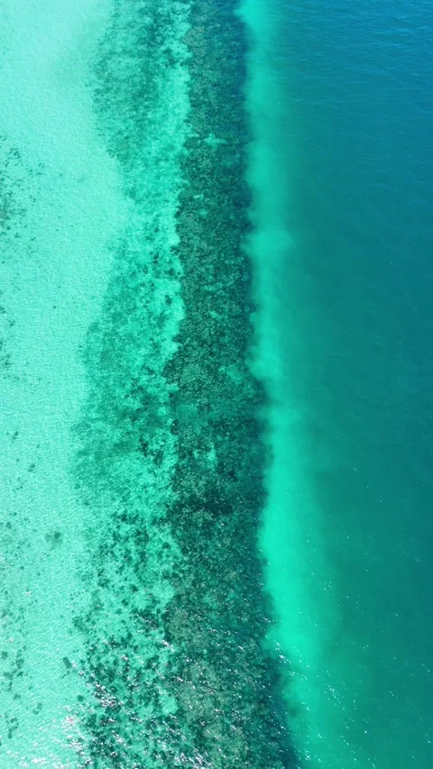 Vertical drone pulling back over turquoise and deep blue waters, Koh Ngai – 4K Stock-Footage 325022375