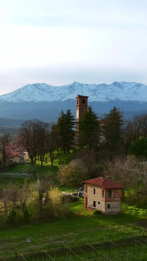 Vertical drone push-in to red brick bell tower over vineyards and Alps panor Vidéo 330948624