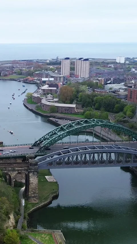 Vertical drone right pan over Wearmouth Bridge and River Wear estuary to North Stockbeeldmateriaal 334572048