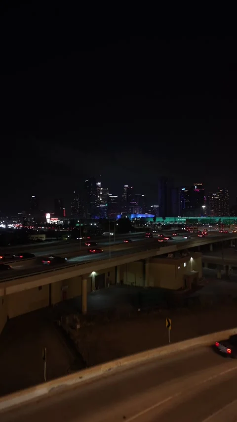 Vertical Drone Rise Beside Illuminated Concrete Freeway Overpass Stock Footage 345703147