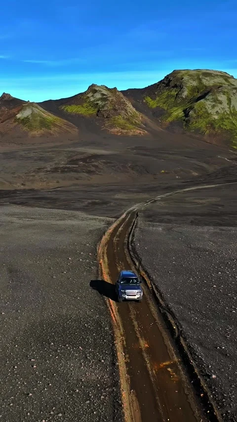 Vertical drone shot of a 4x4 SUV driving a muddy dirt track through Iceland Vídeos de archivo 328265985