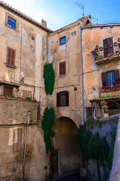 Vertical drone shot of an arch under a residential building in Italy Fotos de archivo