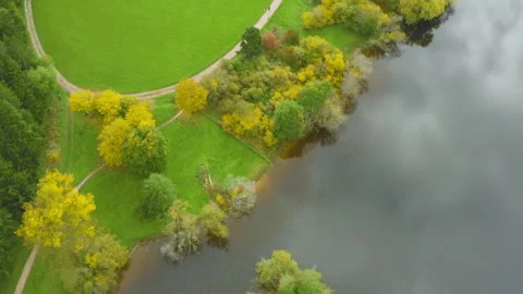 Vertical drone shot of autumn fields and lake in warm colors Vídeos de archivo 318873993
