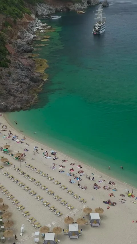 Vertical drone shot of beach with rows of umbrellas and loungers Stock Footage 341779628