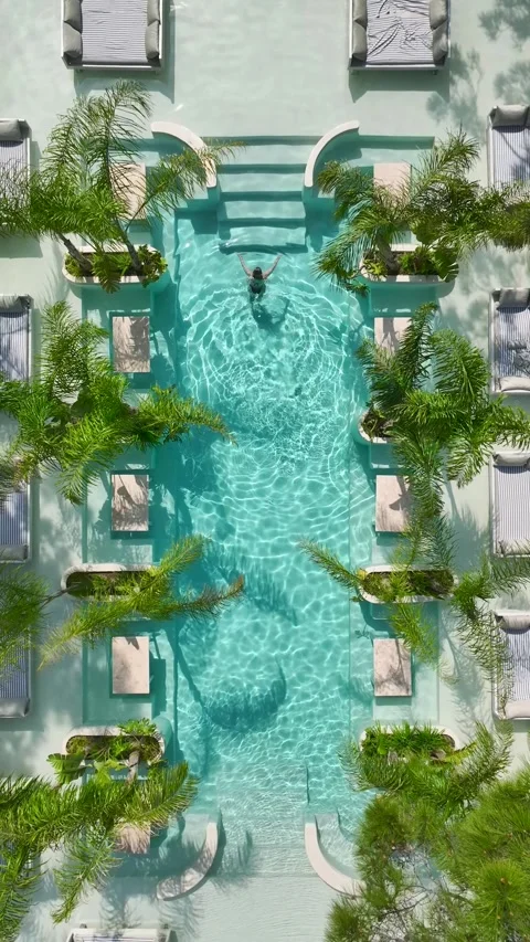 Vertical drone shot of crystal clear resort pool with modern architecture Stock Footage 341813304