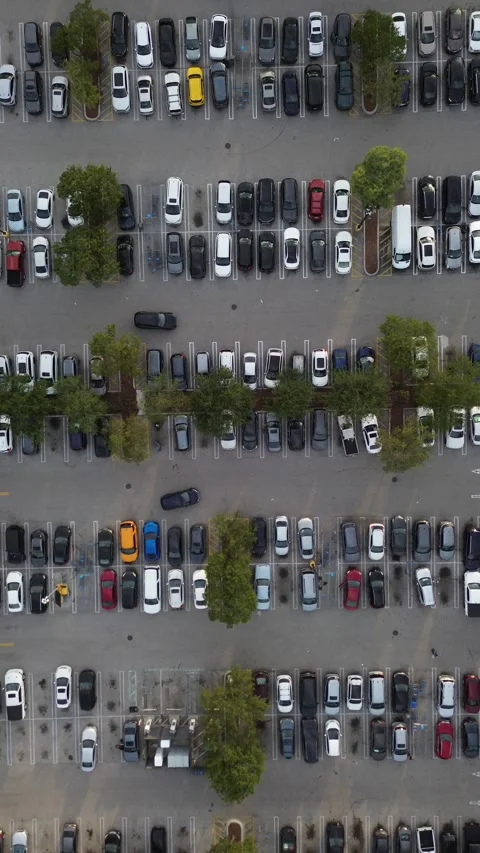 Vertical drone shot descending toward busy parking lot with cars and people Stock Footage 343304108