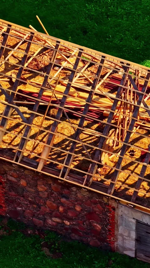 Vertical drone shot of a historic stone building undergoing roof restoration 库存影片 336661338