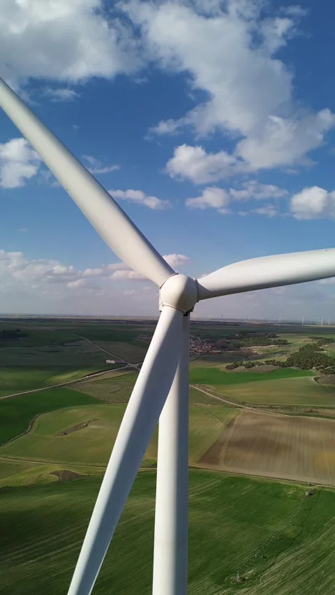 Vertical Drone Shot Moving Away from Wind Turbine Over Green Cereal Field Stock Footage 331119953