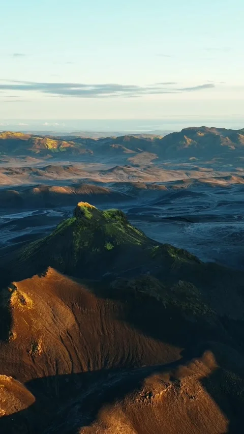 Vertical drone shot over Iceland’s mossy cinder cone and black ash plains at 스톡 동영상 331077005