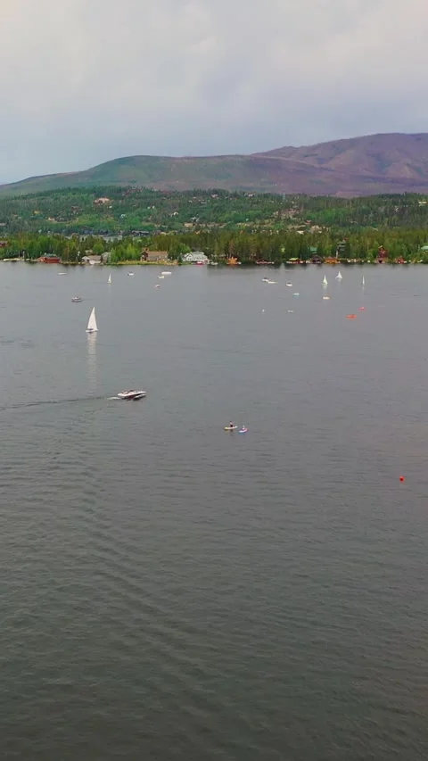 Vertical drone shot over Lake George showing sailboats, motorboats, wooded 스톡 동영상 334109436