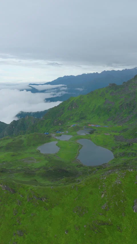 Vertical drone shot of Panchpokhari five lakes surrounded by green peaks in 库存影片 345228740