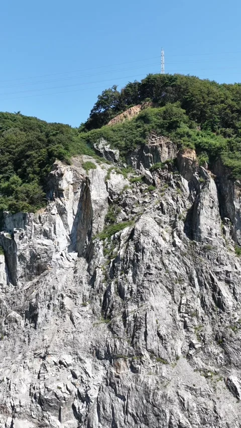 Vertical Drone Shot Pulling Away from Quarry Cliff Stock Footage 319453912