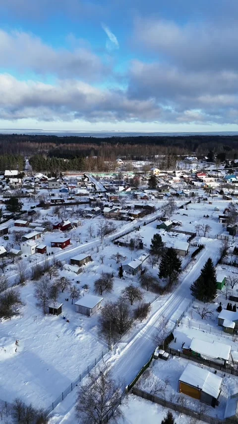 Vertical Drone Shot Pulling Back Above Snowy Village in Northern Europe Stock Footage 335686906