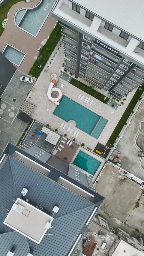 Vertical Drone Shot Residential Pool with Sunbeds and Structured Layout from Stock Footage 341776022