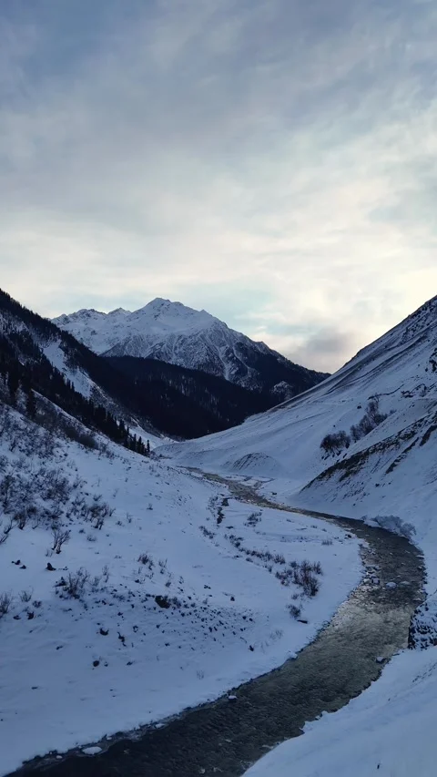 Vertical drone shot of river in frozen mountains Stock Footage 327690986