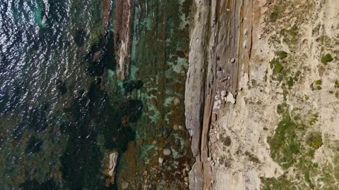 Vertical Drone Shot of Rocky Cliff and Crystal Water Stock Footage 335631263