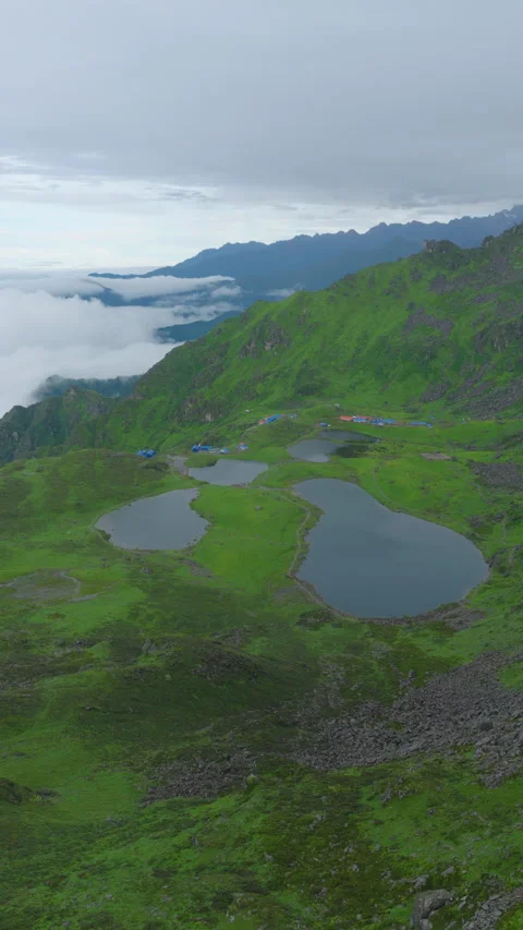 Vertical drone shot of sacred five lakes surrounded by green mountain slopes in Stock Footage 345229292