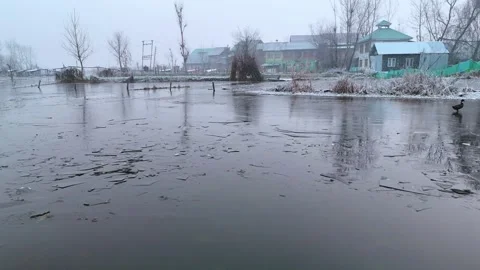 Vertical drone showcasing the poetic silence of Dal Lake’s interiors on frozen Stock Footage 311020738