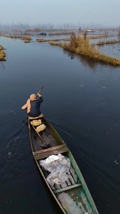 Vertical drone shows the fierce resolve of boatmen pushing through frozen Dal Stock Footage 311019995