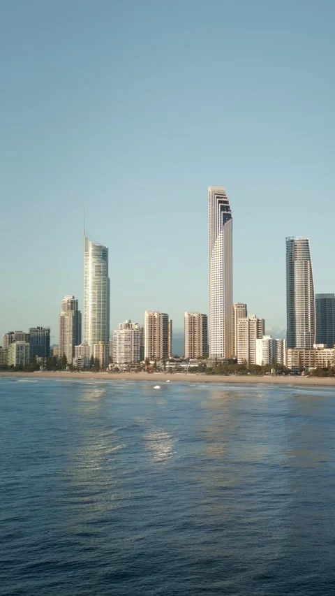 Vertical drone surfers boards ocean further out Surfers Paradise skyline Vídeo Stock 329005323