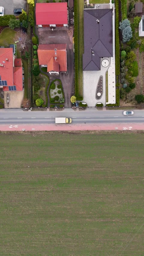 Vertical Drone Top Down Following White Van Between Field And Residences Video stock 330750543