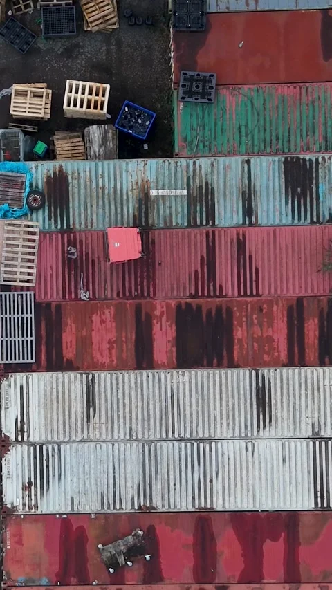Vertical drone top-down reverse over colorful shipping containers by warehouse Stock Footage 331455051