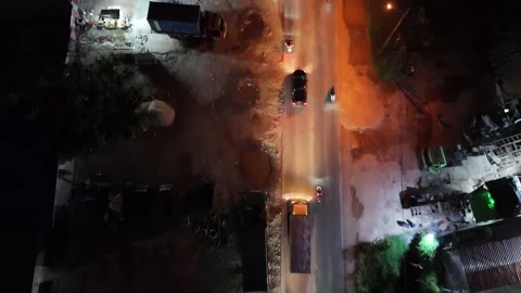Vertical Drone Tracking Shot of Busy Urban Night Traffic Over Construction Site Stock Footage 334211636