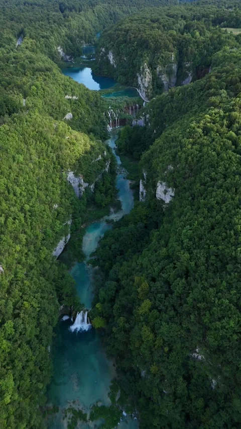 Vertical drone video flying along gorge with river and waterfalls Stock Footage 323504257