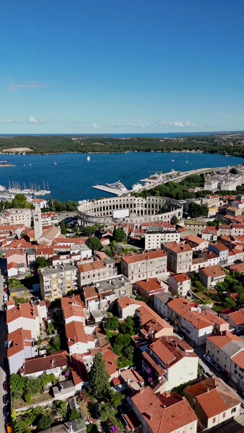Vertical drone video flying over historic city toward ancient amphitheater Stock Footage 323503988