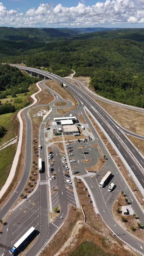 Vertical drone video of gas station and road junction in green valley Stock Footage 323504281