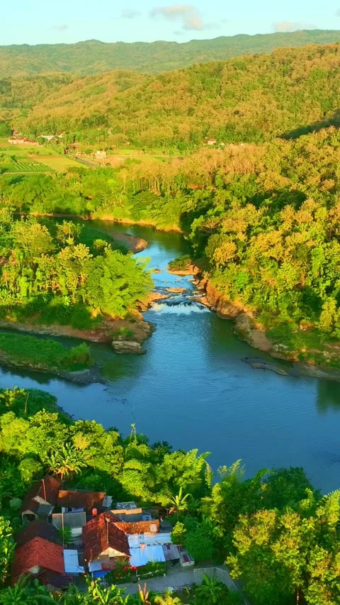 Vertical drone video of river village and hills Stock Footage 336315977