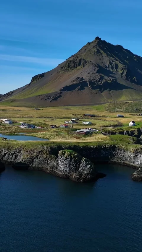 Vertical drone view of Arnarstapi, Iceland, with a dramatic volcanic mountain Stockbeeldmateriaal 348232727