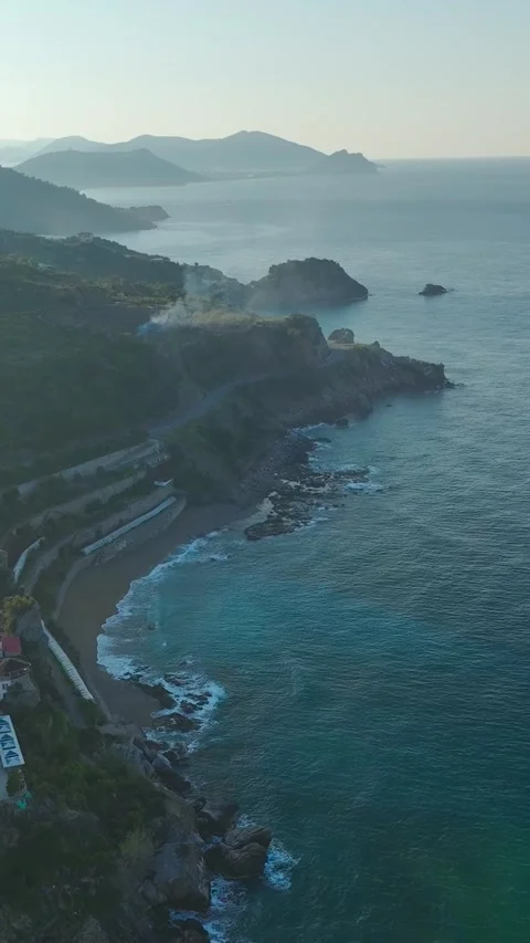 Vertical Drone View Cliffside Terrain with Scattered Houses and Coastal Views Stock Footage 341735775