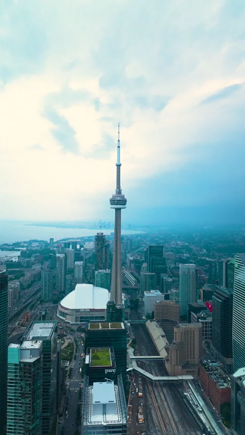 Vertical drone view of CN Tower above Downtown Toronto skyline as storm clouds Stock Footage 328212095