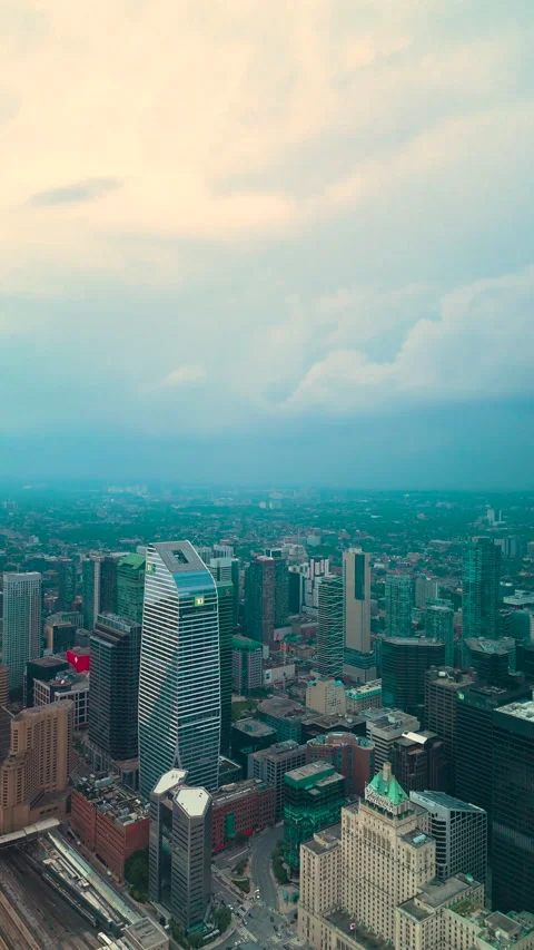 Vertical drone view of CN Tower above Downtown Toronto skyline as storm clouds Stock Footage 328212861