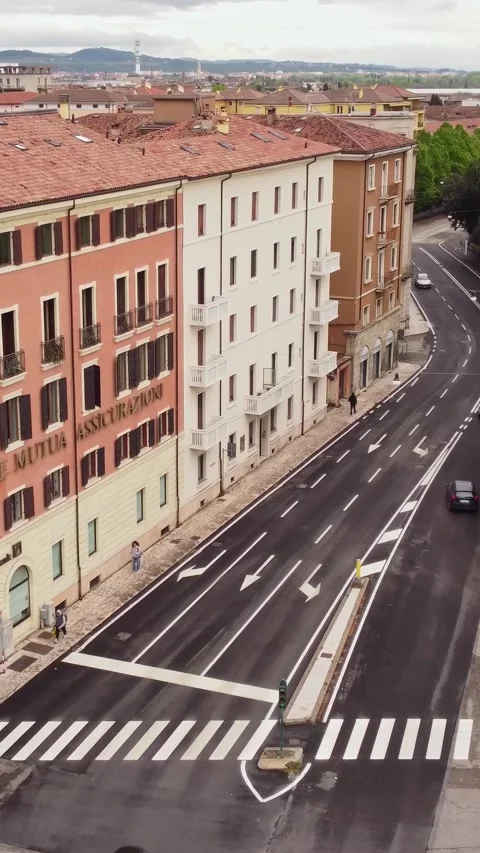 A vertical drone view frames a quiet Verona street next to Porta Nuova, lined Stock Footage 309567949
