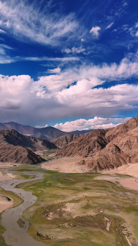 Vertical drone view of a glacial stream slicing through Ladakh’s barren Stock Footage 310900689