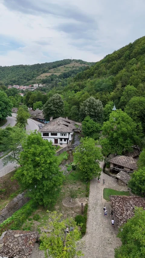 Vertical drone view of a historic stone clock tower in a forest village. Stock Footage 327670149