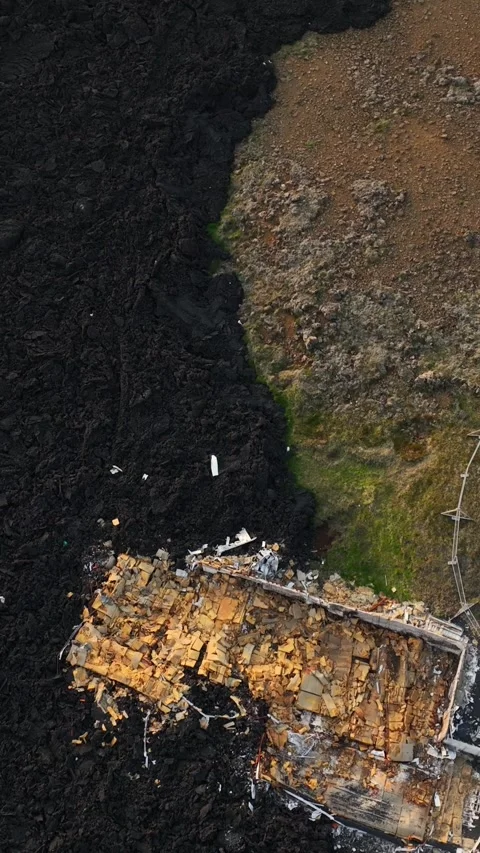 Vertical drone view of a house destroyed by lava in Grindavik, Iceland, with Vídeo Stock 345994710