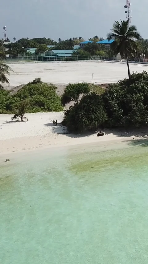 Vertical drone view of local island beach and village infrastructure in Maldives Stockbeeldmateriaal 344257180