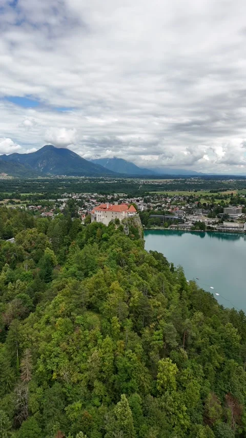 Vertical drone view of a mountain lake and historic clifftop castle Stock Footage 322045207