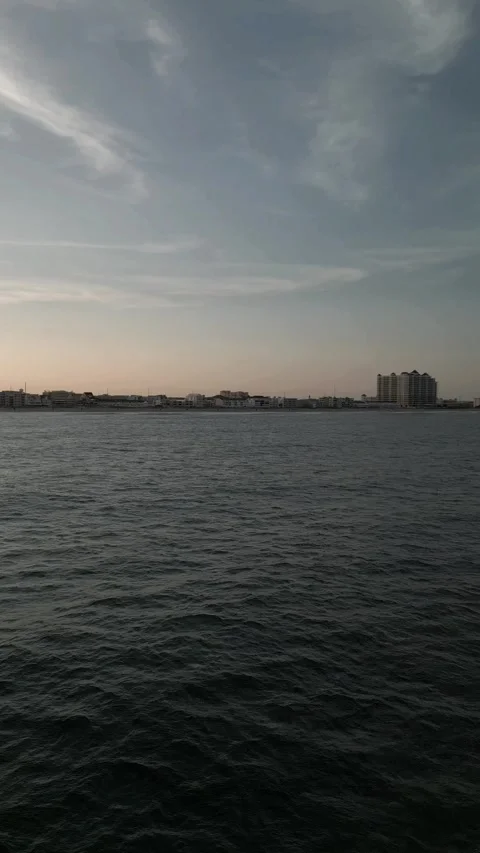 Vertical Drone View of Ocean Water and Coastal City Skyline at Sunset. Stock Footage 330439865
