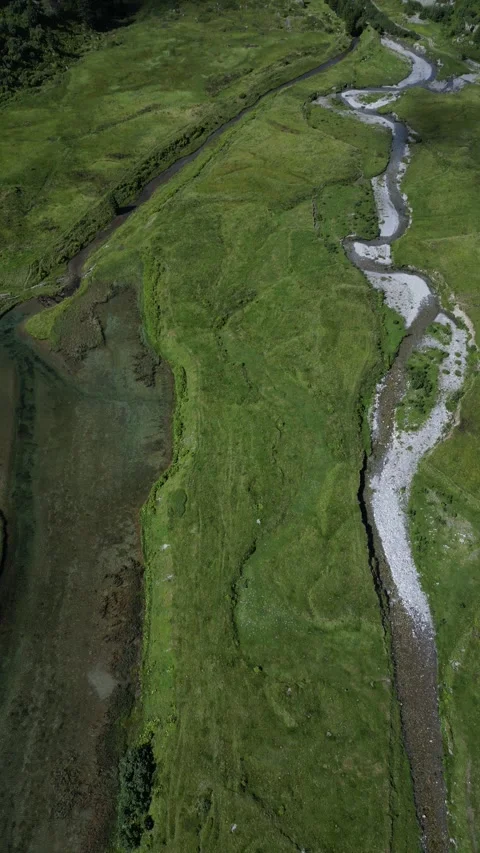 Vertical drone view of remote alpine lake in high mountain landscape Video stock 330748955