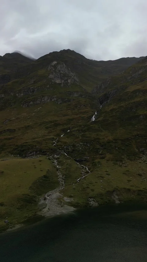 Vertical drone view of remote alpine lake in high mountain landscape Video stock 330749149