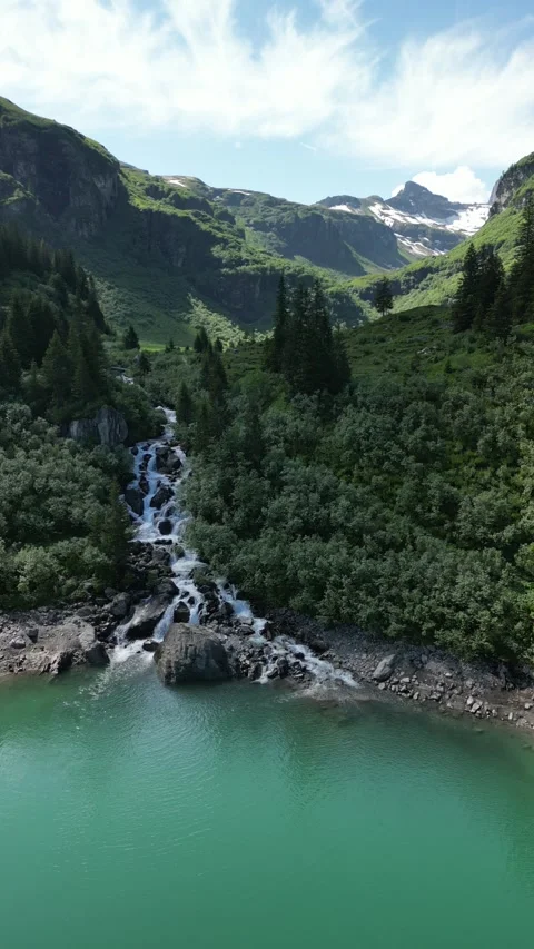 Vertical drone view of remote alpine lake in high mountain landscape Video stock 330749361